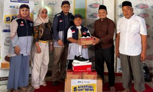 Anak-anak sekolah di Pamijahan Bogor tersenyum sambil memegang paket sepatu baru dari program Alas Kaki Harapan